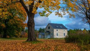 A charming countryside home surrounded by vibrant fall foliage, representing the peaceful allure of hidden US destinations perfect for a scenic and quiet escape.