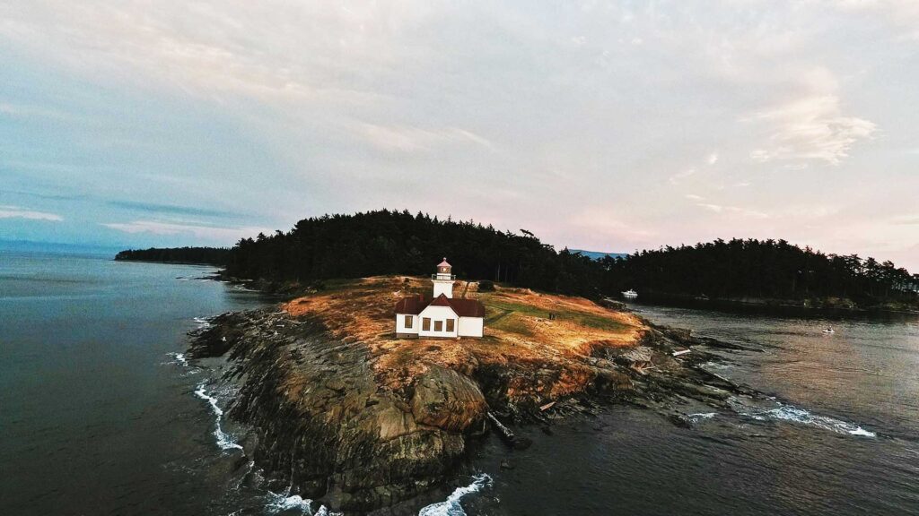 A remote lighthouse on a rugged shoreline of the San Juan Islands, one of the most peaceful hidden US destinations in Washington State.