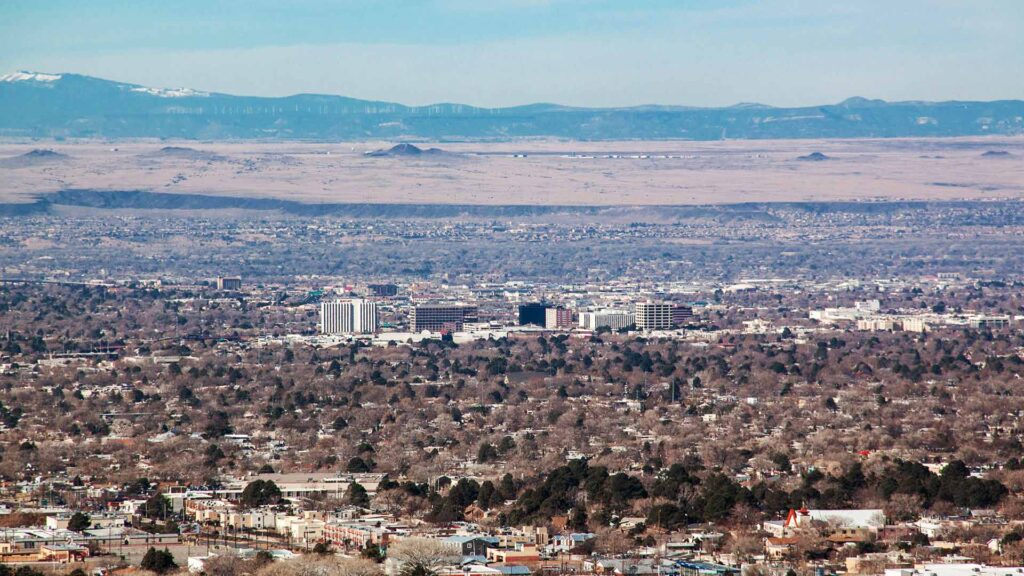 Scenic view of Albuquerque, New Mexico with mountain backdrop—an ideal destination for affordable family vacations blending culture, nature, and city life.
