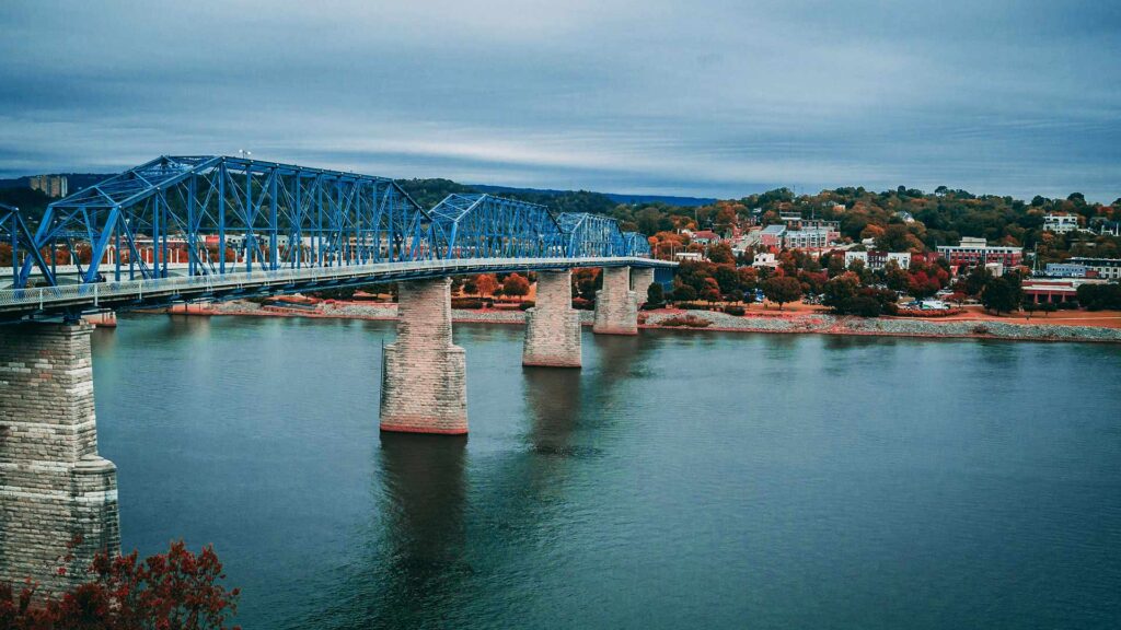 Scenic view of the blue Walnut Street Bridge over the Tennessee River in Chattanooga—an ideal spot for affordable family vacations with a mix of outdoor fun and vibrant city culture.