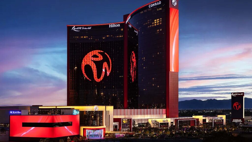 Night view of Resorts World Las Vegas featuring illuminated hotel towers with Hilton and Conrad branding, showcasing one of the top luxury hotels in Las Vegas.