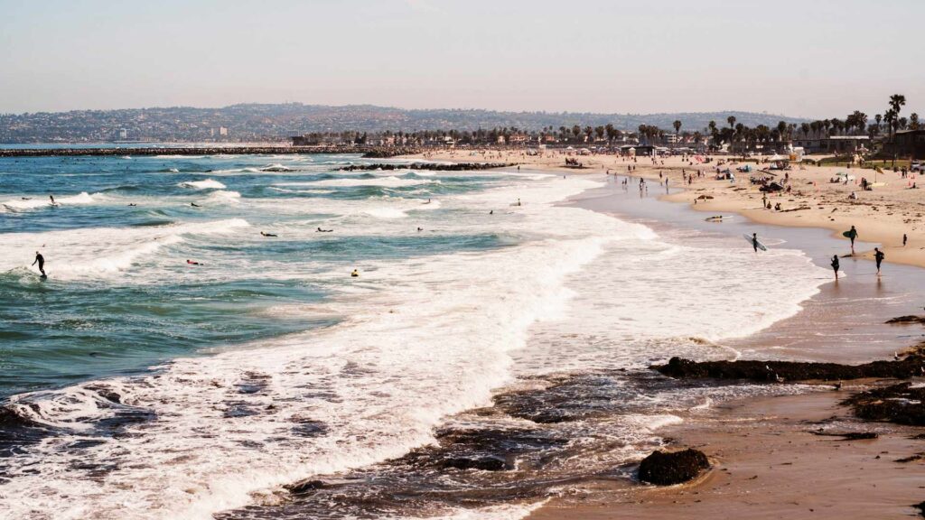 Families enjoying the beach in San Diego, California—perfect for affordable family vacations with sun, surf, and sand.