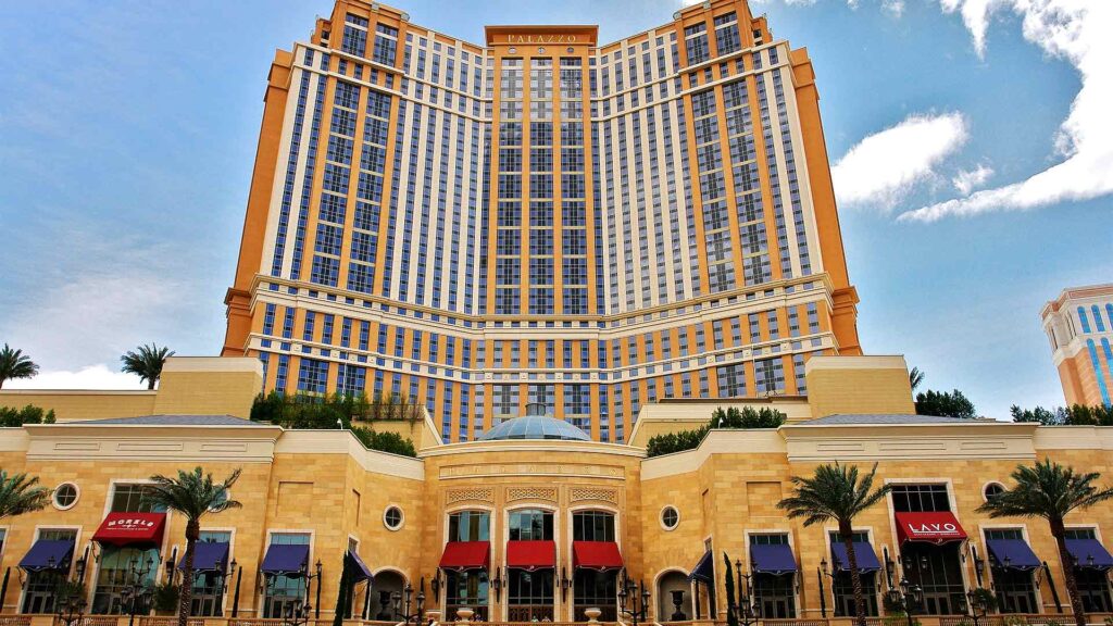 View of The Palazzo at The Venetian, a stunning luxury hotel in Las Vegas with its impressive tower and upscale exterior, featuring restaurants and shops at the base.