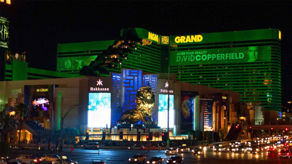 Night view of the iconic MGM Grand Las Vegas, featuring the glowing green hotel exterior, gold lion statue, and entrance to Hakkasan nightclub—home to the exclusive SKYLOFTS, one of the top luxury hotels in Las Vegas.