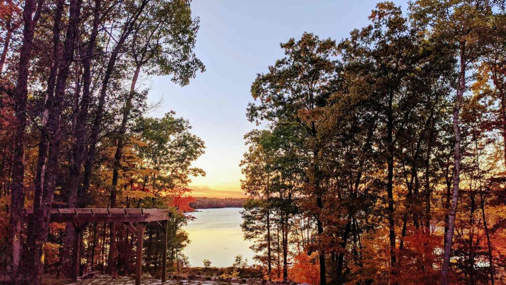 A peaceful lake view framed by autumn trees in Traverse City, Michigan—an ideal destination for affordable family vacations filled with natural beauty and outdoor adventure.