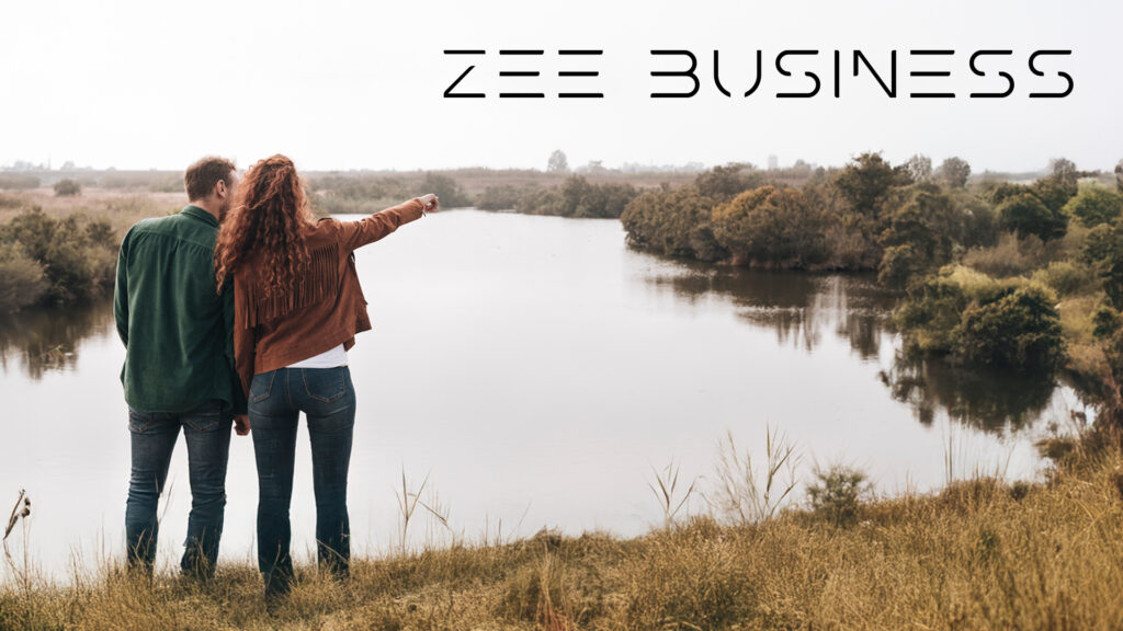 Couple enjoying a scenic riverside view, exploring new destinations with Zee Business travel inspiration