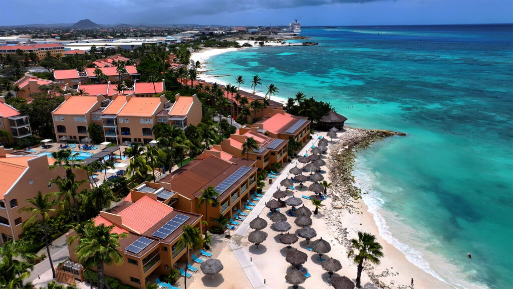 Aerial view of a resort by the beach in Aruba, ideal for all inclusive trips.