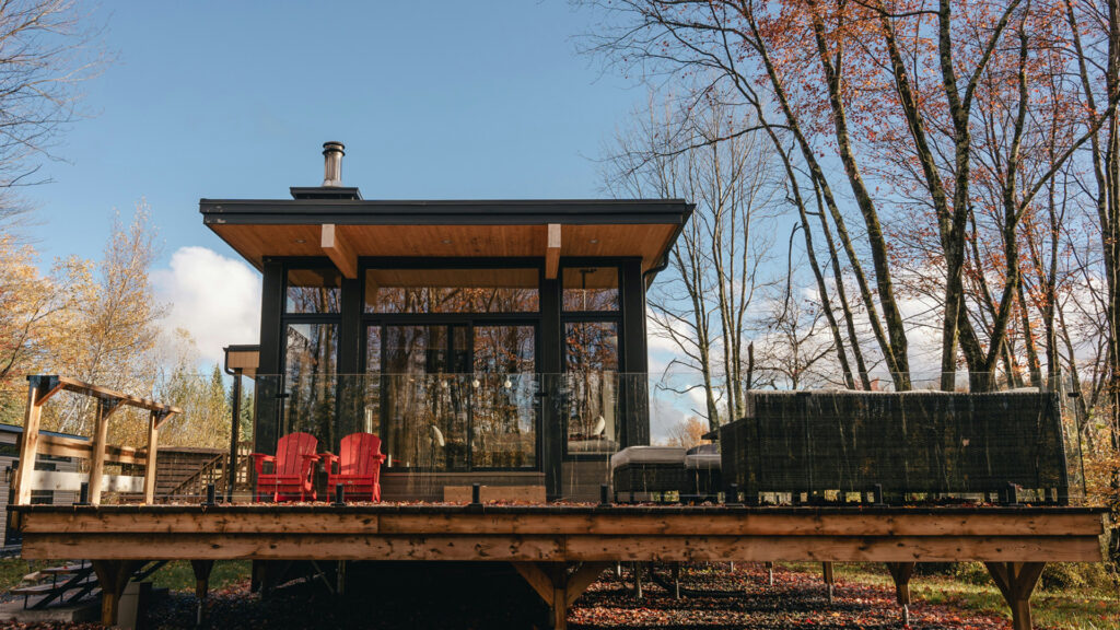 Modern cabin stay surrounded by autumn trees, offering a cozy and affordable option for cheap stays in USA.