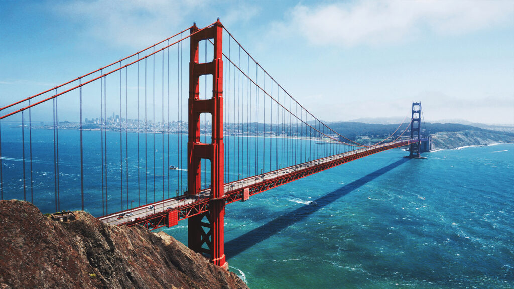A breathtaking view of the Golden Gate Bridge with the San Francisco skyline in the background, offering stunning sights for travelers looking for hotels in San Francisco near iconic landmarks.