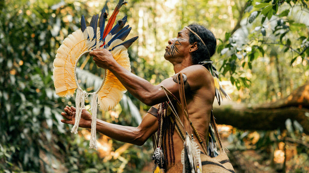 A native american man holding a fan in a forest photo