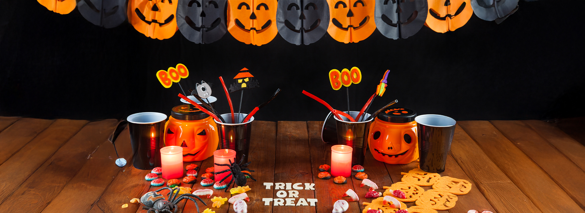 A spooky Halloween setup with pumpkins, candy, and festive decorations like "Trick or Treat" displayed on the table, creating a fun Halloween vibe.
