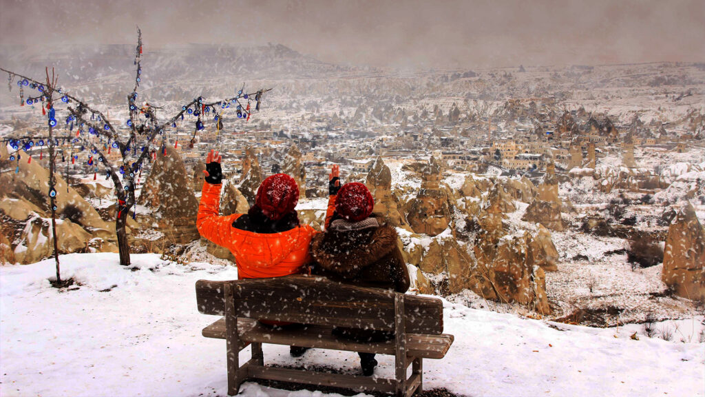 A couple enjoying a snowy view of a winter destination, taking in the scenic beauty of February's landscapes.