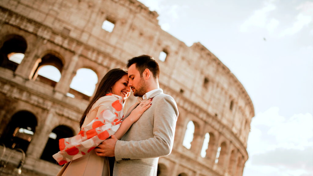 A romantic couple hugging each other with the iconic Colosseum in the background, making for a perfect Valentine getaway in Rome.