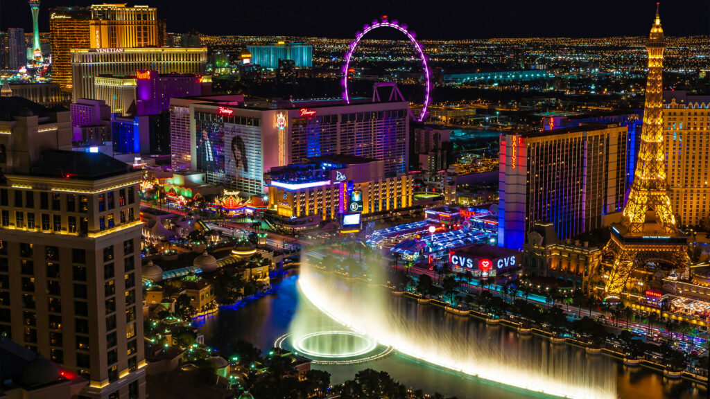 A vibrant view of the Las Vegas Strip at night, featuring hotels, casinos, and lights.