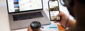 A person browsing hotel listings on a smartphone while sipping coffee, exploring an online hotel booking platform.