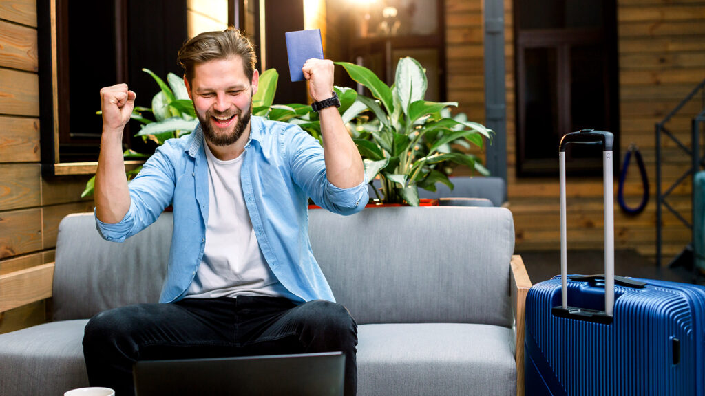 Traveler celebrating after booking a last-minute hotel for summer travel 2026, ready for a spontaneous adventure.