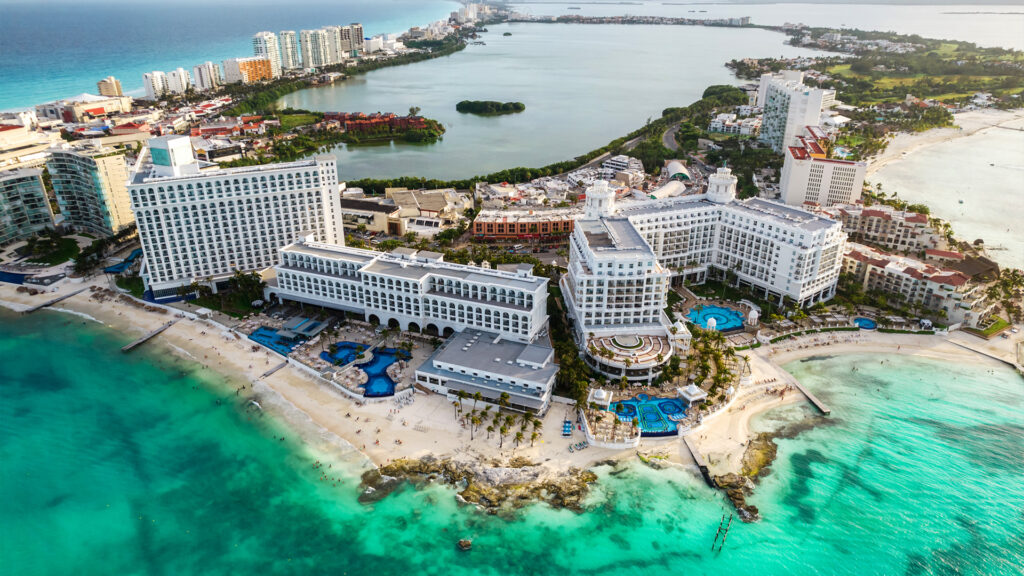 A breathtaking aerial view of a Cancun resort with crystal-clear waters – a perfect destination for Cancun Summer Travel.