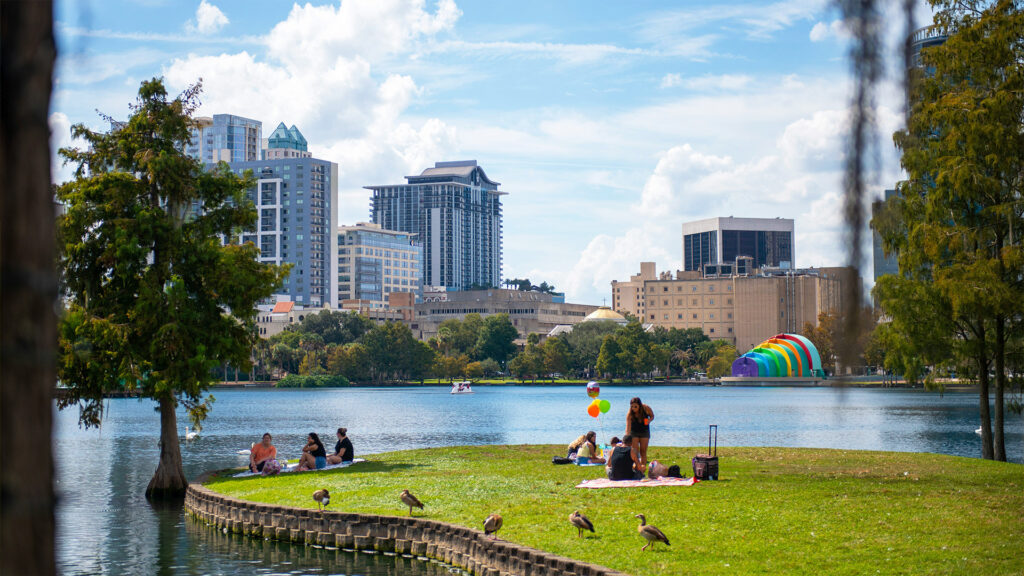 Spring Break Getaways with people relaxing in a lakeside city park on a sunny March day