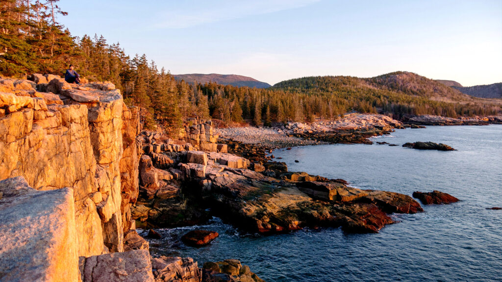 Sunrise over the rocky coastline of Acadia National Park, offering a breathtaking view of the cliffs and ocean.