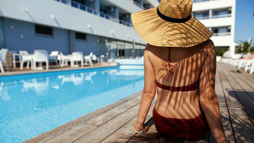 Sitting by the poolside in Cancun, soaking in the sun for a relaxing Cancun Summer Travel experience.