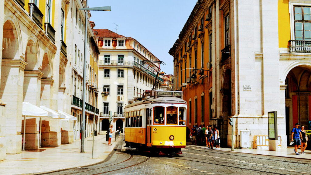 The iconic yellow tram in Lisbon, Portugal, offering solo travelers an unforgettable summer experience through charming city streets.