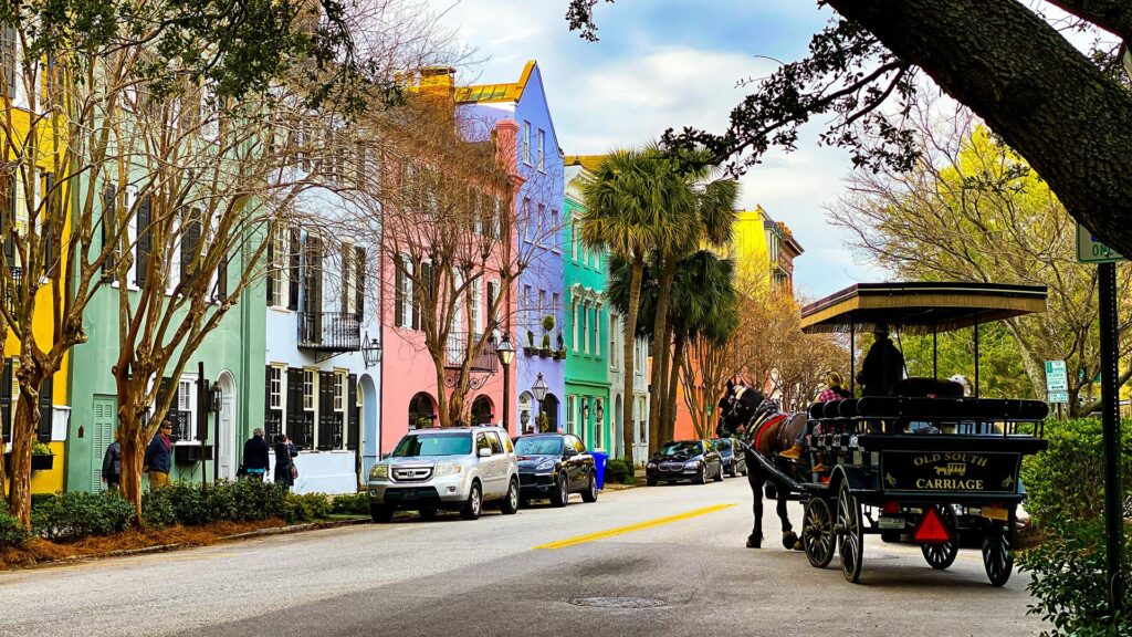 Colorful historic homes and horse carriage on Rainbow Row in Charleston, one of the best coastal cities in America