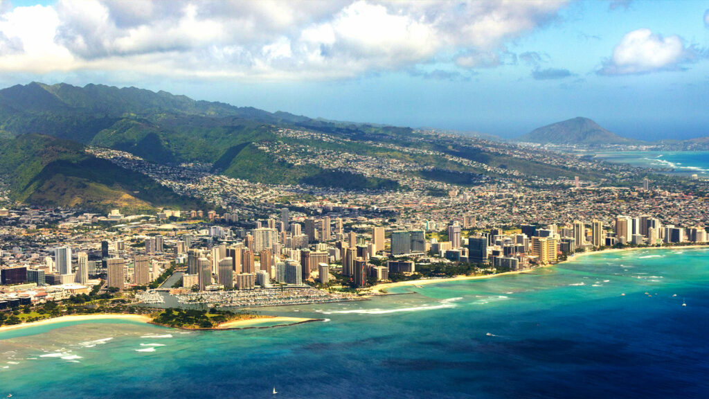 Panoramic view of Honolulu skyline and Waikiki Beach with mountains and ocean, showcasing one of the best coastal cities in America