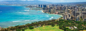 Panoramic view of Honolulu skyline, Waikiki Beach, and turquoise Pacific Ocean with Diamond Head in the background, one of the best coastal cities in America