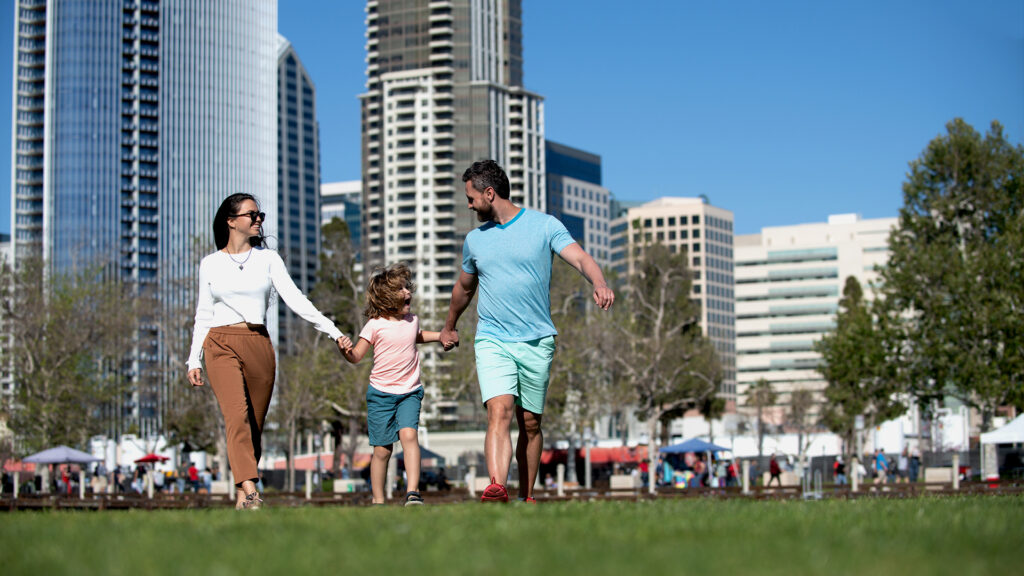 Happy Family Having Fun in a Park of an Urban City